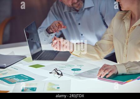 Beautiful business people are using gadgets and laptop, talking during the conference in office over meeting room background Stock Photo