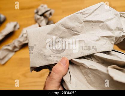 Paris, France - May 22, 2023: A male hand holds a Blauer-Engel paper package made from 100 recycled materials, showcasing an eco-friendly lifestyle indoors after unboxing or packaging manufactured by Papier Sprick Stock Photo