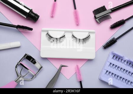 Flat lay composition with fake eyelashes, brushes and tools on color background Stock Photo