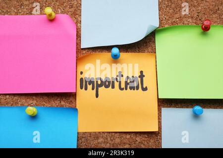Different paper notes pinned to cork board, closeup Stock Photo