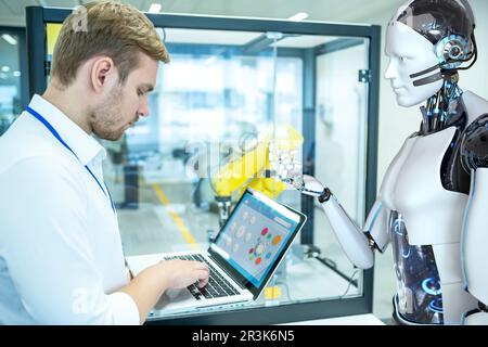 Industrial Robotic Engineer And Humanoid Robot Stock Photo - Alamy