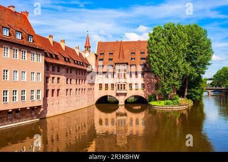 Heilig Geist Spital or Holy Spirit Hospital near Pegnitz river in Nuremberg old town. Nuremberg is the second largest city of Bavaria state in Germany Stock Photo