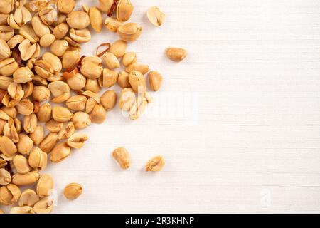 Spicy flavored peanut kernel spilling on white table background. Stock Photo