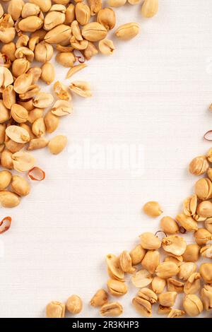 Spicy flavored peanut kernel spilling on white table background. Stock Photo