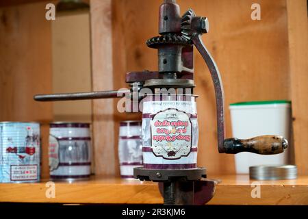 Traditional manual crimping machine, canning maple syrup and closing the cans in a sugar shack at sugar time, Saint-Barthelemy, Lanaudiere, Quebec, Ca Stock Photo
