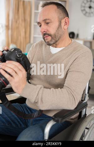 man in wheelchair training to become photographer Stock Photo