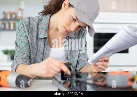 woman installing induction hobs in a kitchen Stock Photo