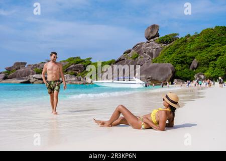 Caucasian men and black women relaxing on a tropical beach in Thailand, Similan Islands Stock Photo