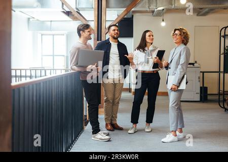 Professionals having a team meeting in an office. Group of business people standing together and discussing their work and projects. business team doi Stock Photo
