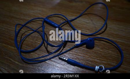 Blue headphones on a wooden background. Stock Photo