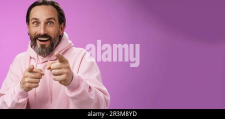 Thrilled energized charismatic happy lucky adult handsome bearded man pointing camera smiling widen eyes gazing impressed see fa Stock Photo