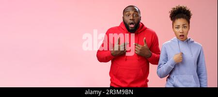 Guys accused feel shocked upset. Portait confused frustrated worried two african-american siblings pointing chest index fingers Stock Photo