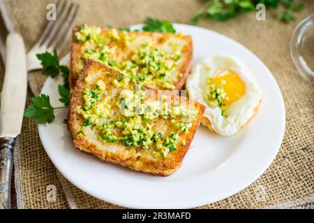 Fried croutons in batter with garlic and herbs in a plate, on a wooden table. Stock Photo