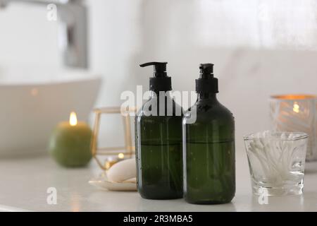 Green soap dispensers on white countertop in bathroom Stock Photo