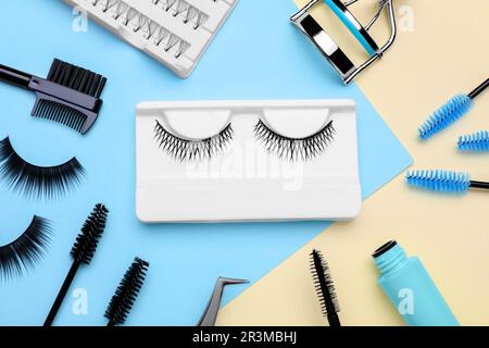 Flat lay composition with fake eyelashes, brushes and tools on color background Stock Photo
