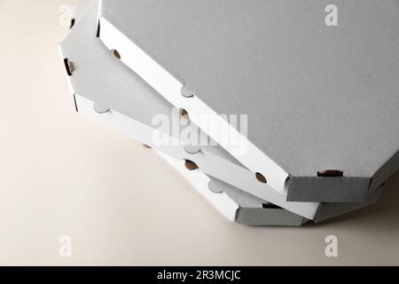Stack of empty pizza boxes on beige background, closeup Stock Photo