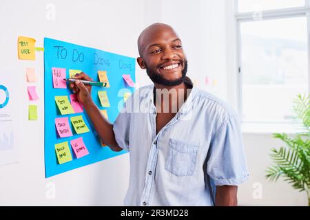 Black developer writes ticket on scrum board, sprint planning coding meeting Stock Photo