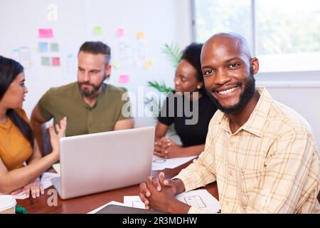 Portrait of smiling Black man, development team, mobile app coding meeting Stock Photo