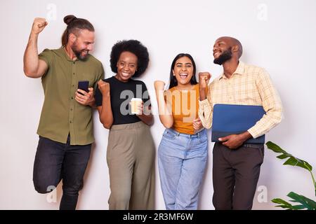 Diverse creative tech team lean against wall and celebrates success, cheer smile Stock Photo