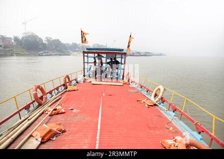 Traditional wooden passenger boat on a Brahmaputra river near Guwahati with river island at the back on a misty summer day, Assam, India Stock Photo