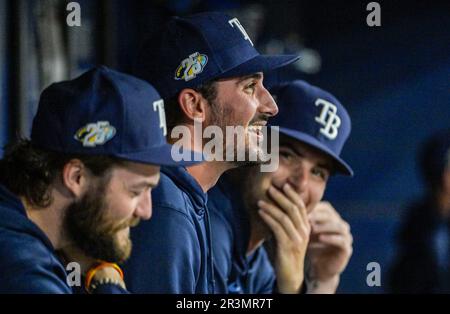 Tampa Bay Rays pitchers Josh Fleming, left to right, Zach Eflin and Shane  McClanahan laugh in the dugout after watching infielder Luke Raley pitch  during a baseball game against the Toronto Blue