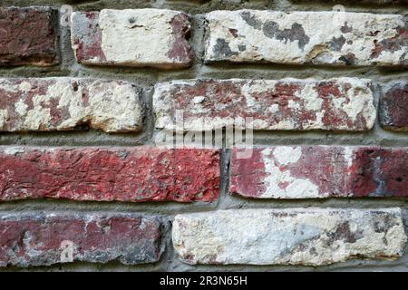 An old dark red brick wall with strong white limescale. Meant as background Stock Photo