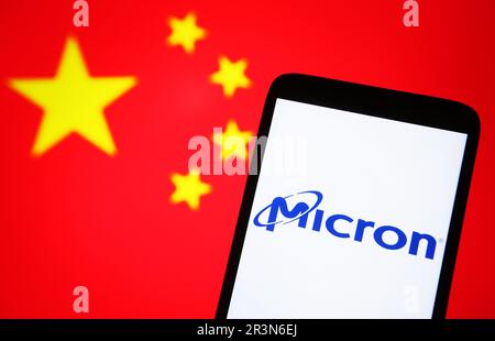 In this photo illustration, Micron logo is seen on a smartphone and flag of China on a pc screen. Stock Photo