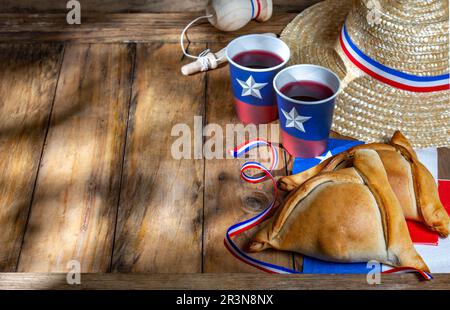 Chilean independence day concept. fiestas patrias. Tipical baked empanadas, wine or chicha, fat and play emboque. Decoration for Stock Photo