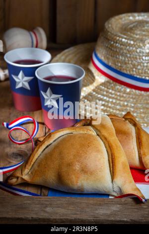 Chilean independence day concept. fiestas patrias. Tipical baked empanadas, wine or chicha, fat and play emboque dish and drink Stock Photo