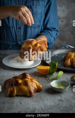 Woman preparing Pan de muertos bread of the dead for Mexican day of the dead Stock Photo