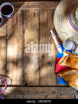 Chilean independence day concept. fiestas patrias. Tipical baked empanadas, wine or chicha, fat and play emboque. Decoration for Stock Photo