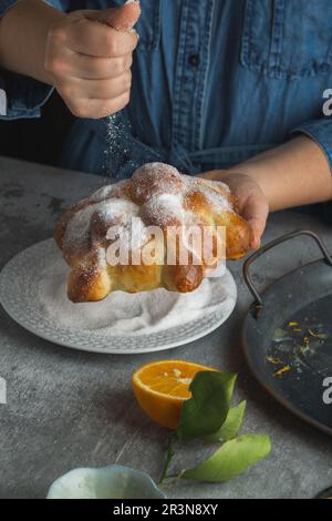 Woman preparing Pan de muertos bread of the dead for Mexican day of the dead Stock Photo