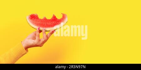 Bitten watermelon slice in hand Stock Photo