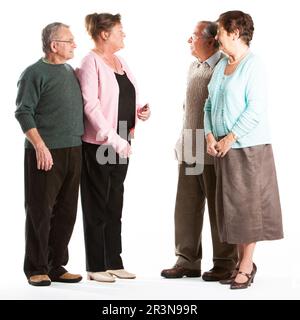 Senior Citizens: Friends talking. 2 senior couples having an informal chat. Full length portrait, isolated on white. From a series of related images. Stock Photo