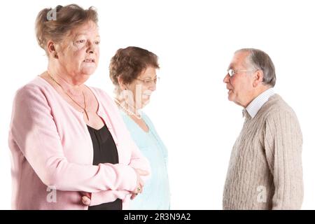 Senior Citizens: An Uncertain Gaze. A moment of contemplation for a senior lady with talking background friends. From a series of related images. Stock Photo