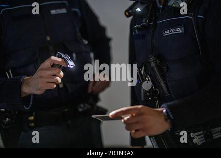 Stuttgart, Germany. 24th May, 2023. Two police officers use their new lamps to check an ID card during an operation, for example. Credit: Christoph Schmidt/dpa/Alamy Live News Stock Photo