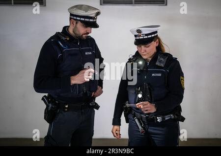 Stuttgart, Germany. 24th May, 2023. Two police officers use their new lamps to check an ID card during an operation, for example. Credit: Christoph Schmidt/dpa/Alamy Live News Stock Photo