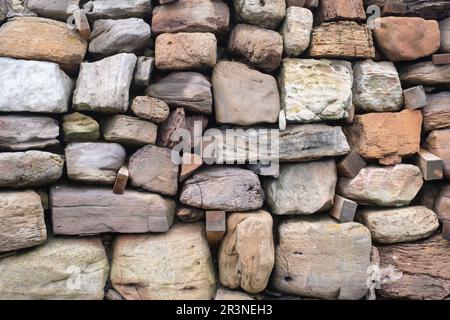 Close up view of a wall showing weathered stones near the harbour in Crail, Fife, Scotland. Stock Photo