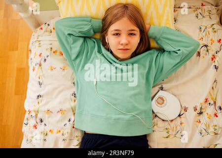 Teenage girl displaying CD and listening to music iin her room Stock Photo