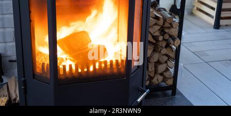 Fuel briquettes made of pressed sawdust for kindling the furnace - economical alternative eco-friendly fuel for the fireplace in Stock Photo