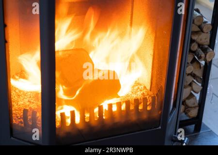 Fuel briquettes made of pressed sawdust for kindling the furnace - economical alternative eco-friendly fuel for the fireplace in Stock Photo