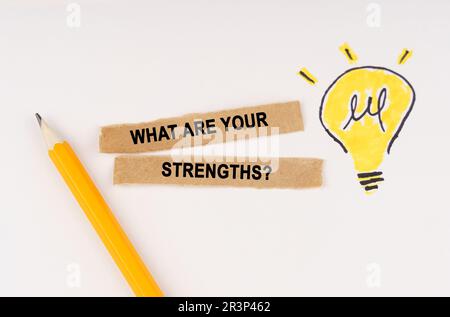 Business and education concept. A luminous light bulb is drawn on a white background, next to it lies a pencil and pieces of paper with the inscriptio Stock Photo