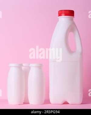 White plastic bottle for milk and dairy products on a pink background Stock Photo