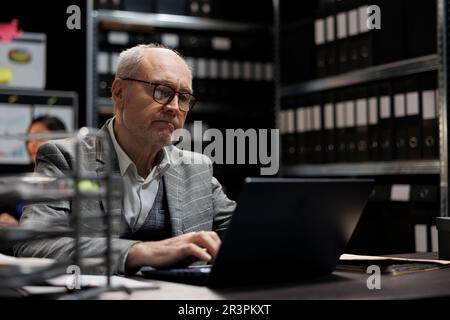 Senior private detective checking case Stock Photo