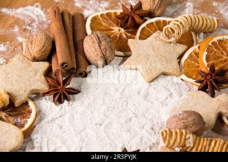 biscuits, star anise, cinnamon sticks, dried orange slices and nuts with meal Stock Photo