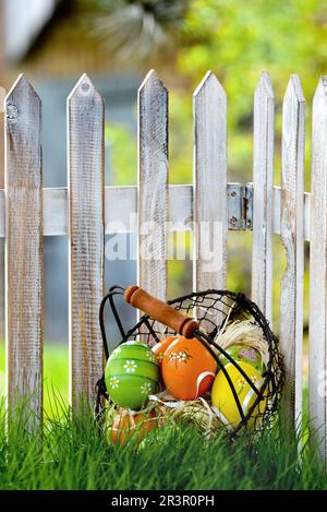 basket with Easter eggs at a garden fence, Germany, composing Stock Photo