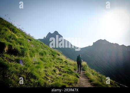 hiker on the road, Midi d'Ossau peak, 2884 meters, Pyrenees National Park, Pyrenees Atlantiques, France. Stock Photo