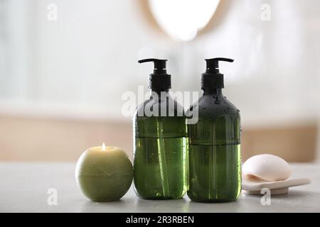 Green soap dispensers on white countertop in bathroom Stock Photo