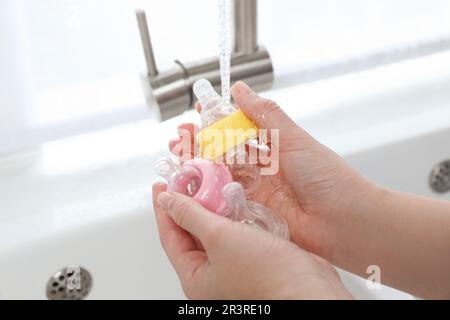 Washing baby nipples. Mother's hand washing the baby nipples Stock Photo -  Alamy