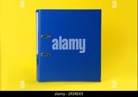 Blue hardcover office folder on yellow background Stock Photo